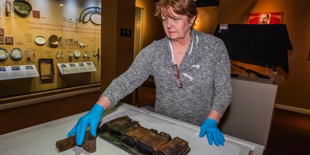 Alexander Klingelhofer, Experiential Media Group executive director for collections examining artifacts.