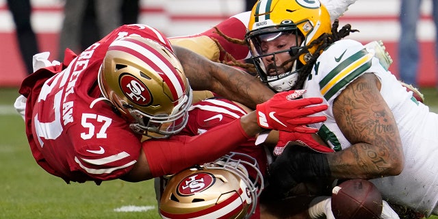 Green Bay Packers offensive lineman Billy Turner, right, recovering a loose ball next to San Francisco 49ers linebacker Dre Greenlaw (57) and defensive end Nick Bosa during Sunday's game. (AP Photo/Tony Avelar)