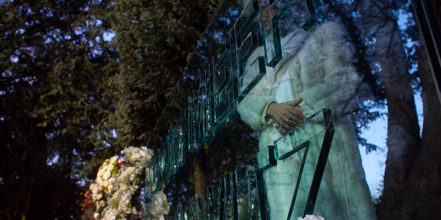 A woman prays at the "Auschwitz Never Again" monument after the National Holocaust Commoration in Amsterdam, Netherlands, Sunday, Jan. 26, 2020, which marked the 75th anniversary of the liberation of Auschwitz concentration and extermination camp. (AP Photo/Peter Dejong)