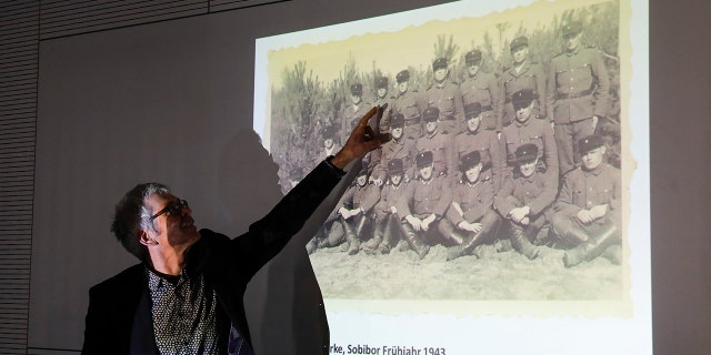 Historican Martin Cueppers points at a man, presumably former security guard John Demjanjuk, at the Nazi death camp Sobibor during a news conference of newly discovered photos from the Sobibor camp in Berlin, Germany, Tuesday, Jan. 28, 2020. (AP Photo/Markus Schreiber)