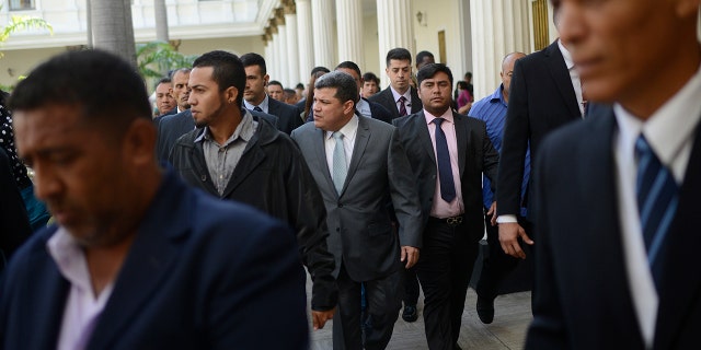 Lawmaker Luis Parra, center, who broke with opposition leader Juan Guaido and claims the presidency of the National Assembly, leaves after leading a session at the National Assembly in Caracas, Venezuela, Tuesday, Jan. 21, 2020. (AP Photo/Matias Delacroix)