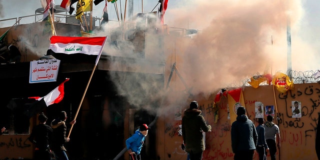 U.S. troops fired tear gas on Wednesday to disperse pro-Iran protesters who were gathered outside the U.S. Embassy compound in Baghdad for a second day as dozens of pro-Iranian militiamen and their supporters had camped out at the gates of the embassy in Baghdad, where they stayed the night. (AP Photo/Khalid Mohammed)