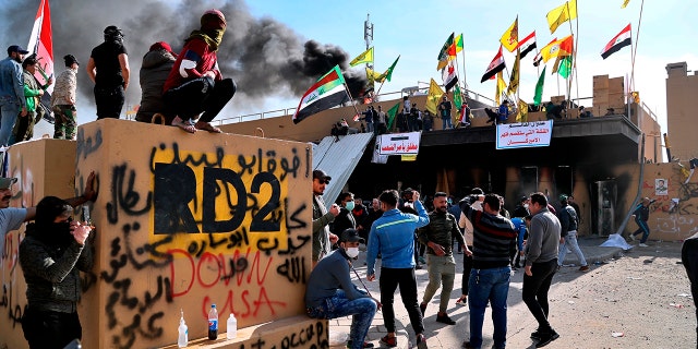 Pro-Iranian militiamen and their supporters set a fire during a sit-in in front of the U.S. embassy in Baghdad, Iraq, Wednesday, Jan. 1, 2020. (AP Photo/Khalid Mohammed)