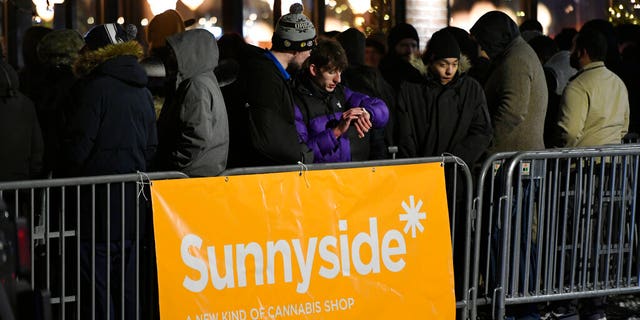 A long line of people brave the cold as they wait to be the first in Illinois to purchase recreational marijuana at Sunnyside dispensary Wednesday, Jan. 1, 2020, in Chicago. (AP Photo/Paul Beaty)