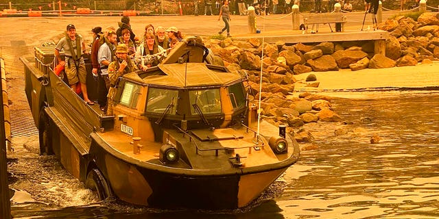 Evacuees are transported in a lighter, amphibious, resupply, cargo (LARC) amphibious vehicle, from Mallacoota, Victoria, on Jan. 2, 2020. Navy ships plucked hundreds of people from beaches and tens of thousands were urged to flee before hot weather and strong winds in the forecast worsen Australia's already devastating wildfires.