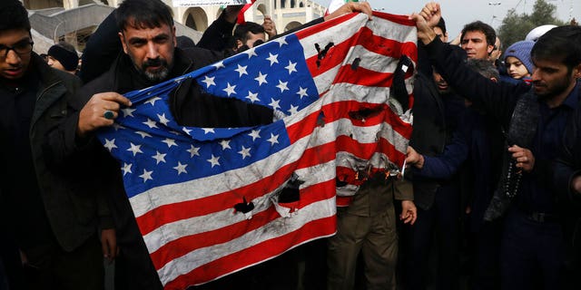 Protesters burn a U.S. flag during a demonstration over the U.S. airstrike in Iraq that killed Iranian Revolutionary Guard Gen. Qassem Soleimani, in Tehran, Iran, Jan. 3, 2020. Iran has vowed