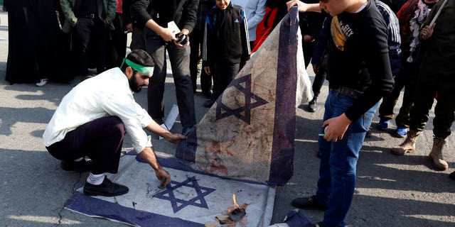 Protesters burn representations of Israeli flag during a demonstration over the U.S. airstrike in Iraq that killed Iranian Revolutionary Guard Gen. Qassem Soleimani, in Tehran, Iran, Jan. 3, 2020. Iran has vowed "harsh retaliation" for the U.S. airstrike near Baghdad's airport that killed Tehran's top general and the architect of its interventions across the Middle East, as tensions soared in the wake of the targeted killing. (AP Photo/Vahid Salemi)