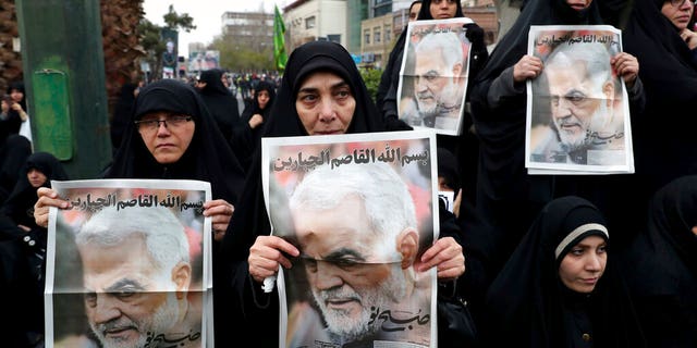 Protesters hold up posters of Gen. Qassem Soleimani while mourning during a demonstration over the U.S. airstrike in Iraq that killed Iranian Revolutionary Guard Gen. Qassem Soleimani, in Tehran, Iran, Saturday Jan. 4, 2020. Iran has vowed