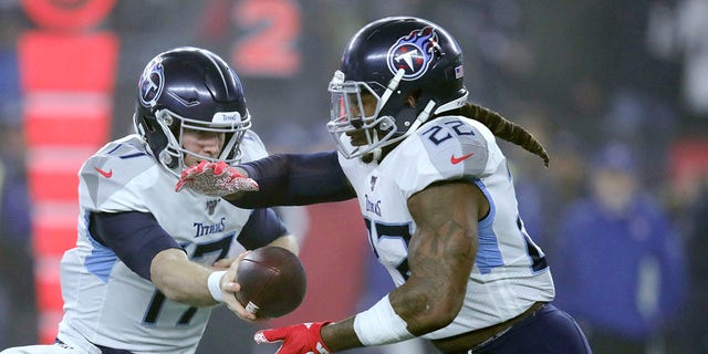 Tennessee Titans quarterback Ryan Tannehill, left, hands off to running back Derrick Henry in the first half of an NFL wild-card playoff football game against the New England Patriots, Saturday, Jan. 4, 2020, in Foxborough, Mass. (AP Photo/Charles Krupa)