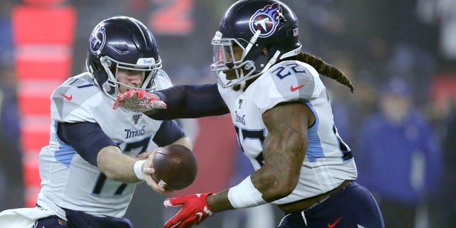 Tennessee Titans quarterback Ryan Tannehill, left, hands off to running back Derrick Henry in the first half of an NFL wild-card playoff football game against the New England Patriots, Saturday, Jan. 4, 2020, in Foxborough, Mass. (AP Photo/Charles Krupa)