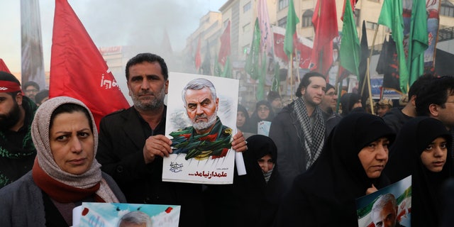 Mourners holding posters of Iranian Gen. Qassem Soleimani attend a funeral ceremony for him and his comrades, who were killed in Iraq in a U.S. drone strike on Friday, at the Enqelab-e-Eslami (Islamic Revolution) Square in Tehran, Iran, Monday, Jan. 6, 2020. (AP Photo/Ebrahim Noroozi)