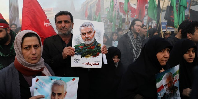 Mourners holding posters of Iranian Gen. Qassem Soleimani attend a funeral ceremony for him and his comrades, who were killed in Iraq in a U.S. drone strike on Friday, at the Enqelab-e-Eslami (Islamic Revolution) Square in Tehran, Iran, Monday, Jan. 6, 2020. (AP Photo/Ebrahim Noroozi)