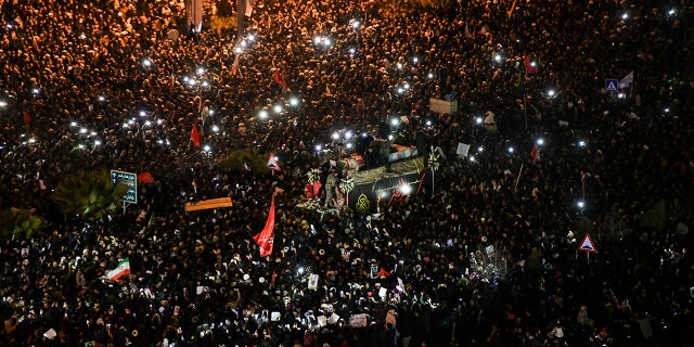 Mourners surround a truck carrying the flag draped coffins of Gen. Qassem Soleimani and his comrades in the holy city of Qom south of the capital Tehran, Iran, Monday, Jan. 6, 2020. (Amir Hesaminejad/Tasnim News Agency via AP)