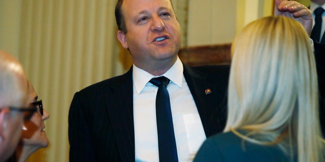 Colorado Gov. Jared Polis waits outside the chambers of the House of Representatives to be introduced and deliver his State of State speech in the State Capitol Thursday, Jan. 9, 2020, in Denver. (AP Photo/David Zalubowski)