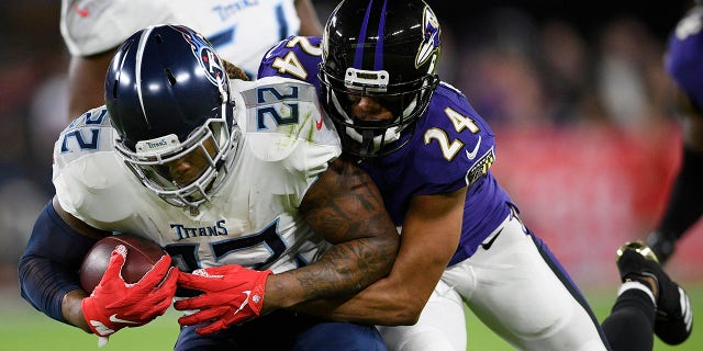 Baltimore Ravens cornerback Marcus Peters (24) hits Tennessee Titans running back Derrick Henry (22) during an NFL divisional playoff football game, Saturday, Jan. 11, 2020, in Baltimore. (Associated Press)