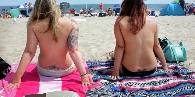 In this Aug. 26, 2017 photo, women go topless during Go Topless Day at Hampton Beach, N.H. The Supreme Court is leaving in place the public nudity convictions of three women who removed their bathing suit tops on a New Hampshire beach as part of a campaign advocating for the rights of women to go topless. (Ioanna Raptis/Portsmouth Herald seacoastonline.com via AP)