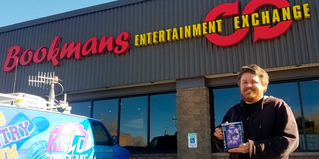 Bookmans Entertainment Exchange general manager Micheil Salmons stands in front of the store in Flagstaff, Ariz., holding a DVD autographed by Star Wars actor Mark Hamill. (Scott Buffon/Arizona Daily Sun via AP)
