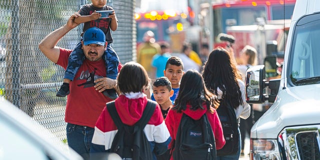 Children evacuate the Park Avenue Elementary school in Cudahy, Calif., on Tuesday. Fire officials say fuel apparently dumped by the aircraft returning to LAX fell onto the school's playground. (AP Photo/Damian Dovarganes)