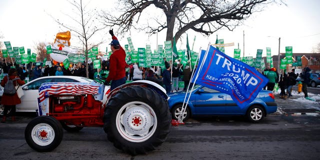 A Trump supporter rides by Democratic presidential candidate Sen. Amy Klobuchar, D-Minn., rally before a Democratic presidential primary debate Tuesday, Jan. 14, 2020, hosted by CNN and the Des Moines Register in Des Moines, Iowa. (AP Photo/Patrick Semansky)