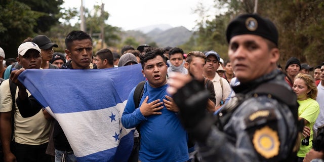 Honduran migrants walking in a group stop before Guatemalan police near Agua Caliente Guatemala on Thursday on the border with Honduras. Hundreds of Honduran migrants started walking and hitching rides Wednesday from the city of San Pedro Sula in a bid