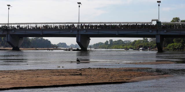 Migrants crowd the the bridge spanning the Suchiate River on the border between Guatemala and Mexico in Ciudad Hidalgo, Saturday, Jan. 18, 2020. More than a thousand Central American migrants surged onto the bridge as Mexican National Guardsmen attempted to impede their journey north. (AP Photo/Marco Ugarte)