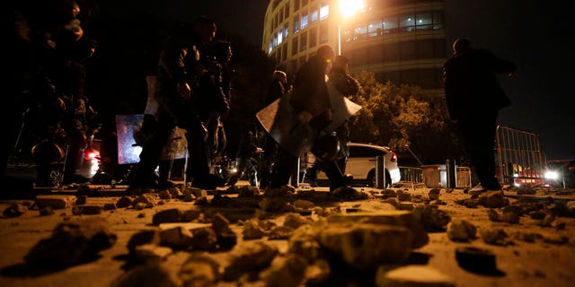 Lebanese police walk after dispersing a protest in Beirut, Lebanon, Saturday, Jan. 18, 2020. 