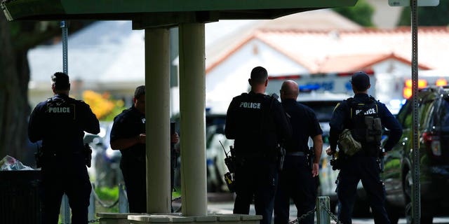 Honolulu police prepare to take defensive positions with their weapons after a shooting and domestic incident at a residence in Honolulu.