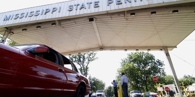 Employees leave the front gate of the Mississippi State Penitentiary in Parchman, Miss. Gov. Tate Reeves on Monday said he will take steps to close part of the prison after a series of deaths and unsanitary living conditions.