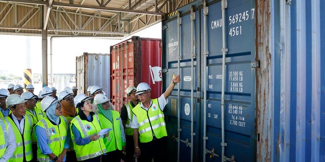 Malaysia's Environment Minister Yeo Bee Yin, third from left, inspects a container with plastic waste at a port in Butterworth, Malaysia, Monday, Jan. 20, 2020.