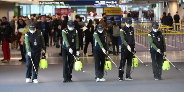Workers spray antiseptic solution on the arrival lobby amid rising public concerns over the possible spread of a new coronavirus at Incheon International Airport in Incheon, South Korea, Tuesday, Jan. 21, 2020. Heightened precautions were being taken in China and elsewhere Tuesday as governments strove to control the outbreak of a novel coronavirus that threatens to grow during the Lunar New Year travel rush.