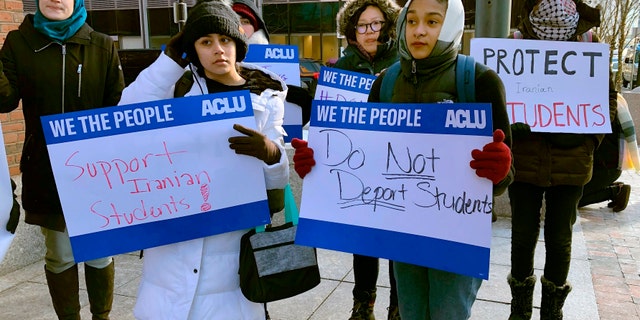 Protesters stand outside the federal courthouse where a hearing was scheduled for Northeastern University student Shahab Dehghani, Tuesday, Jan. 21, 2020, in Boston. Dehghani arrived on a flight into Boston on Monday but was detained by U.S. Customs and Border Patrol at Logan International Airport and then was deported. (AP Photo/Philip Marcelo)