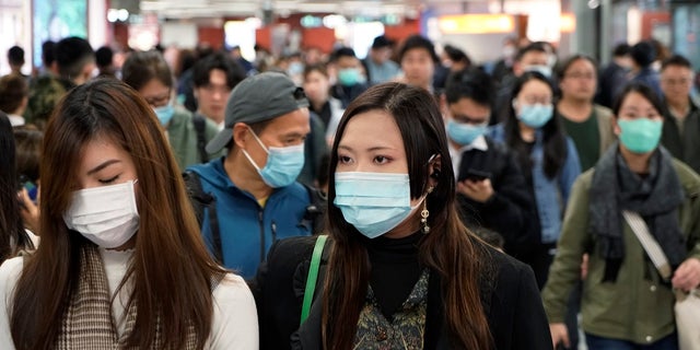 Passengers wear masks to prevent an outbreak of a new coronavirus in a subway station, in Hong Kong, Wednesday, Jan. 22, 2020. The first case of coronavirus in Macao was confirmed on Wednesday, according to state broadcaster CCTV. The infected person, a 52-year-old woman, was a traveller from Wuhan. (AP Photo/Kin Cheung)