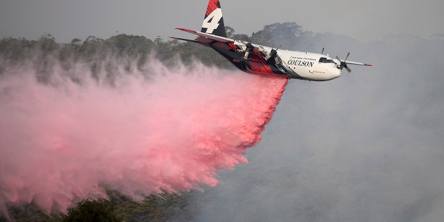 Jan. 10, 2020: Rural Fire Service large air tanker 134, operated by Coulson Aviation in the U.S. state of Oregon, drops fire retardant on a wildfire burning close to homes at Penrose, Australia, 165km south of Sydney. Three American crew members died Thursday when this C-130 Hercules aerial water tanker crashed while battling wildfires in southeastern Australia, officials said. (Dan Himbrechts/AAP Image via AP)