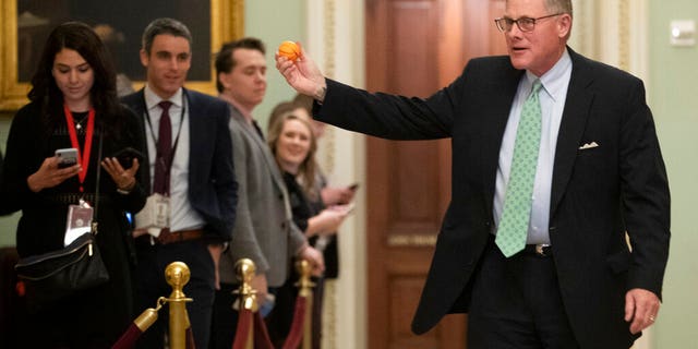 Sen. Richard Burr R-N.C., displaying a stress ball outside the impeachment trial Thursday. (AP Photo/Steve Helber)