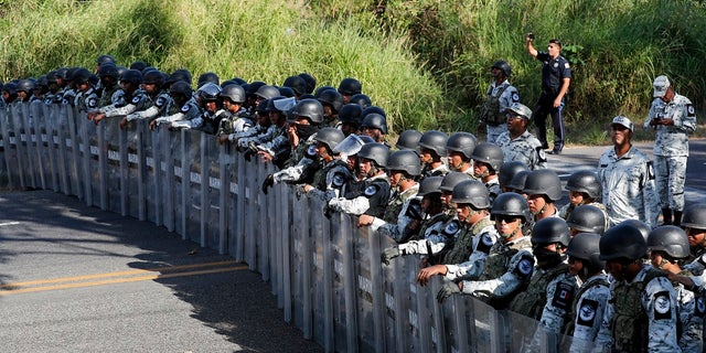 Mexican National Guardsmen block the passage of migrants on the highway leading to Tapachula, Mexico on Thursday. Hundreds of Central American migrants crossed the Suchiate River into Mexico from Guatemala Thursday after a days-long standoff with security forces. (AP Photo/Marco Ugarte)