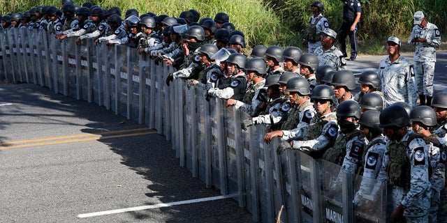 Mexican National Guardsmen block the passage of migrants on the highway leading to Tapachula, Mexico on Thursday. Hundreds of Central American migrants crossed the Suchiate River into Mexico from Guatemala Thursday after a days-long standoff with security forces. (AP Photo/Marco Ugarte)