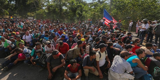 Migrants sit on the highway leading to Tapachula, Mexico on Thursday, where they are blocked by National Guardsmen. (AP Photo/Marco Ugarte)