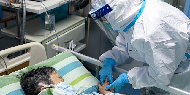 A medical worker attends to a patient in the intensive care unit at Zhongnan Hospital of Wuhan University in Wuhan in central China's Hubei Province. C(Xiong Qi/Xinhua via AP)