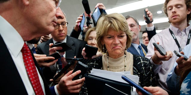 Sen. Lisa Murkowski, R-Alaska, center, and Sen. John Barrasso, R-Wyo., react to the final statement of House Democratic impeachment manager Rep. Adam Schiff, D-Calif., as they speak to the media at the end of a day of an impeachment trial of President Donald Trump on charges of abuse of power and obstruction of Congress, Friday, Jan. 24, 2020, on Capitol Hill in Washington. (AP Photo/Jacquelyn Martin)