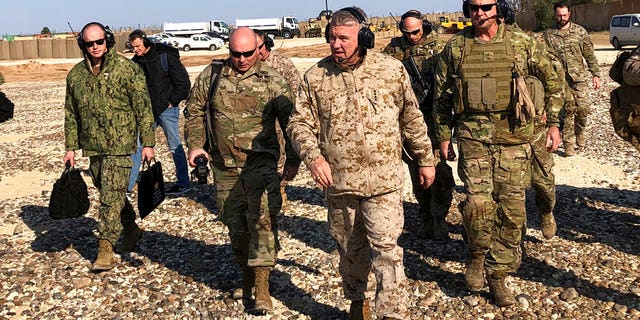 Gen. Frank McKenzie, center front, the top U.S. commander for the Middle East, walks as he visits a military outpost in Syria.