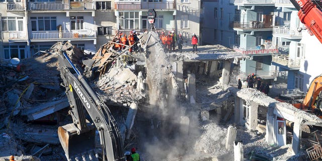 Rescue workers continue to look for people trapped under debris following a strong earthquake that destroyed several buildings on Friday, in Elazig, eastern Turkey, Sunday, Jan. 26, 2020.