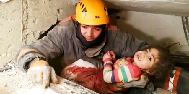 In this image taken from video made available by Ankara Municipality Fire Department shows a rescuer pulling out a girl from the rubble of a collapsed building, in Elazig, Turkey, Saturday Jan. 25, 2020.