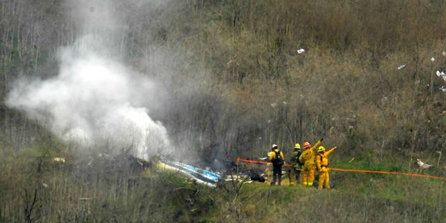 Firefighters working the scene of the helicopter crash where former Kobe Bryant died Sunday in Calabasas, Calif. (AP Photo/Mark J. Terrill)