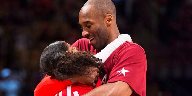 In this February 14, 2016 file photo, Los Angeles Lakers Kobe Bryant (24) kisses his daughter Gianna on the field during warm-up before the NBA All-Star Game first half basketball game in Toronto .  (Mark Blinch / The Canadian Press via AP)