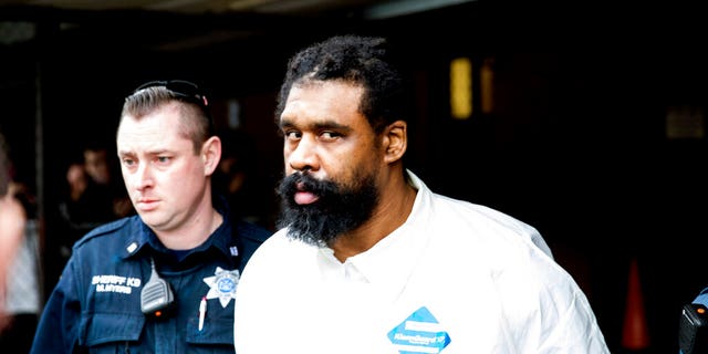 FILE: Ramapo police officers escort Grafton Thomas from Ramapo Town Hall to a police vehicle in Ramapo, N.Y.