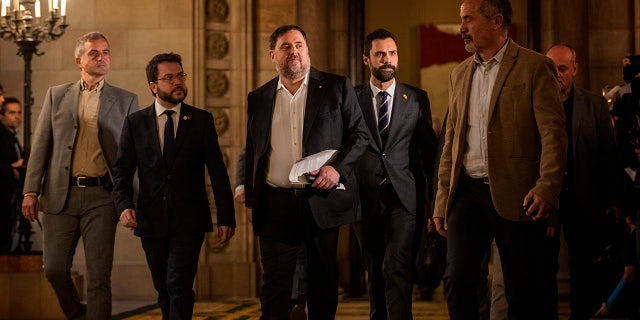 Catalan politician Oriol Junqueras, centre, arrives at the Parliament of Catalonia in Barcelona, Spain, Tuesday, Jan. 28, 2020. The imprisoned leader of the Catalan separatist ERC party Oriol Junqueras and five other former regional Cabinet members who pushed ahead with an illegal independence declaration for Catalonia in 2017 are brought out of prison for the first time to testify at a regional parliamentary committee. (AP Photo/Emilio Morenatti)