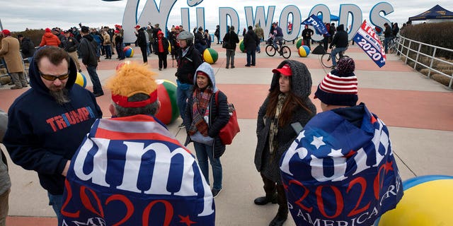 Supporters of President Donald Trump supporters stand in a crowd near the iconic Wildwoods sign near the Wildwoods Convention Center as they wait to enter a campaign rally with Trump, Tuesday, Jan. 28, 2020, in Wildwood, N.J. (AP Photo/Mel Evans)