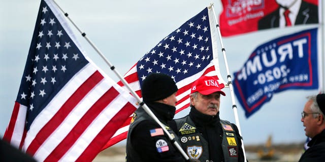 President Donald Trump supporters John Walker, left, and Mike Kufta stand on the Wildwood boardwalk as they wait to attend a campaign rally with Trump, Tuesday, Jan. 28, 2020, in Wildwood, N.J. (AP Photo/Mel Evans)