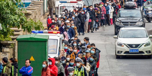 People line up to buy face masks from a medical supply company in Nanning in southern China's Guangxi Zhuang Autonomous Region, Wednesday, Jan. 29, 2020. Countries began evacuating their citizens Wednesday from the Chinese city hardest-hit by a new virus that has now infected more people in China than were sickened in the country by SARS. (Chinatopix via AP)