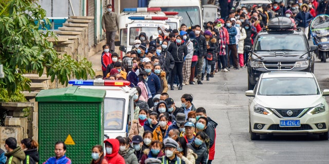 People line up to buy face masks from a medical supply company in Nanning in southern China's Guangxi Zhuang Autonomous Region, Wednesday, Jan. 29, 2020. Countries began evacuating their citizens Wednesday from the Chinese city hardest-hit by a new virus that has now infected more people in China than were sickened in the country by SARS. (Chinatopix via AP)